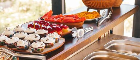 Un bufé con diversos alimentos y una rama decorativa con adornos azules.