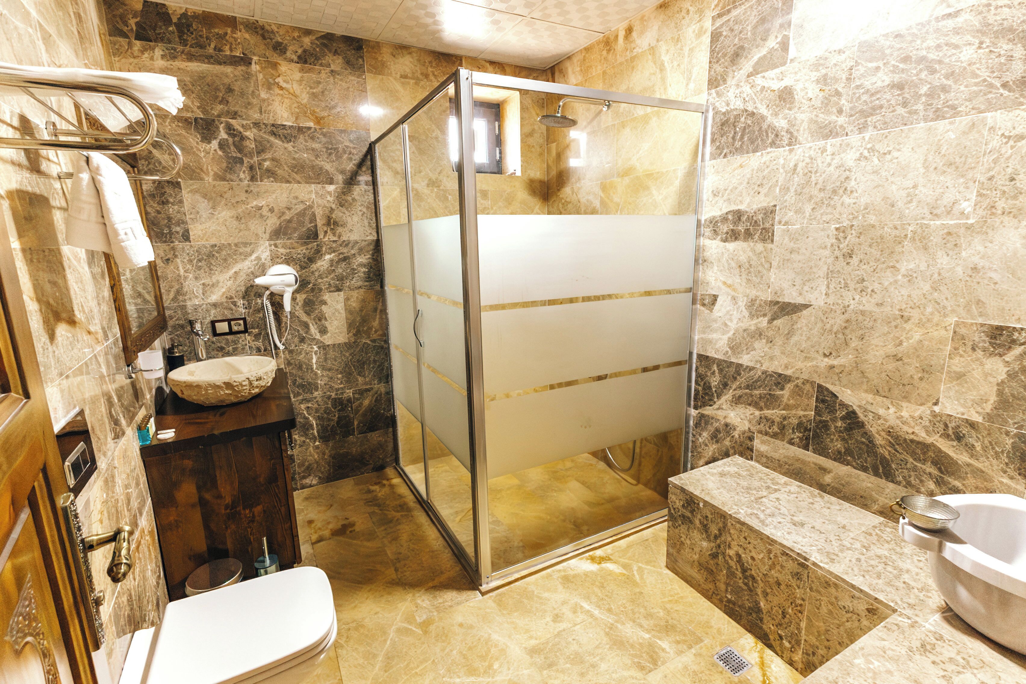 Un baño con ducha de vidrio, lavamanos y bañera.