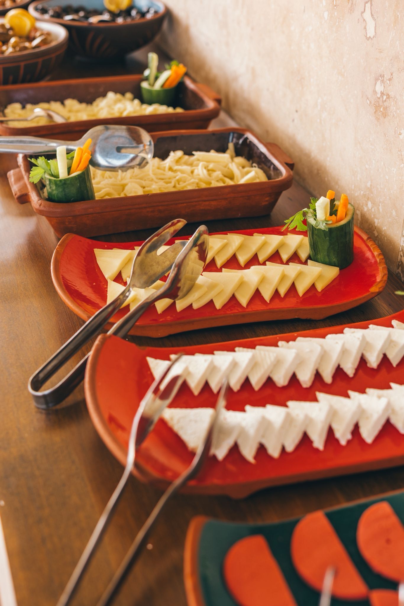 A buffet table with various food items and utensils.