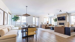Un vaste espace de vie comprenant une table à manger, un canapé et une cheminée.