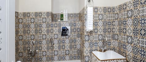 A bathroom with patterned tiles, a toilet, a sink, and a shower.