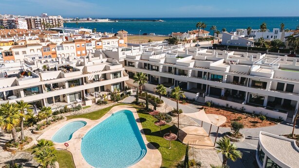 Un complexe hôtelier comprenant plusieurs bâtiments, une piscine et offrant une vue sur la mer.