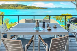 Enjoy a casual meal with a view of the turquoise sea and lush island from this outdoor dining area.
