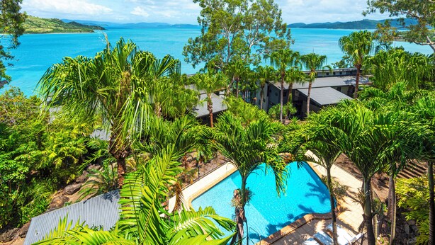 A pool surrounded by lush greenery and overlooking a clear blue sea. - Shorelines 17 - Hamilton Island  (Hamilton Island)