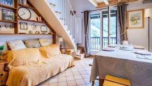 Une pièce confortable avec un lit, une table à manger et un escalier menant à l’étage supérieur.