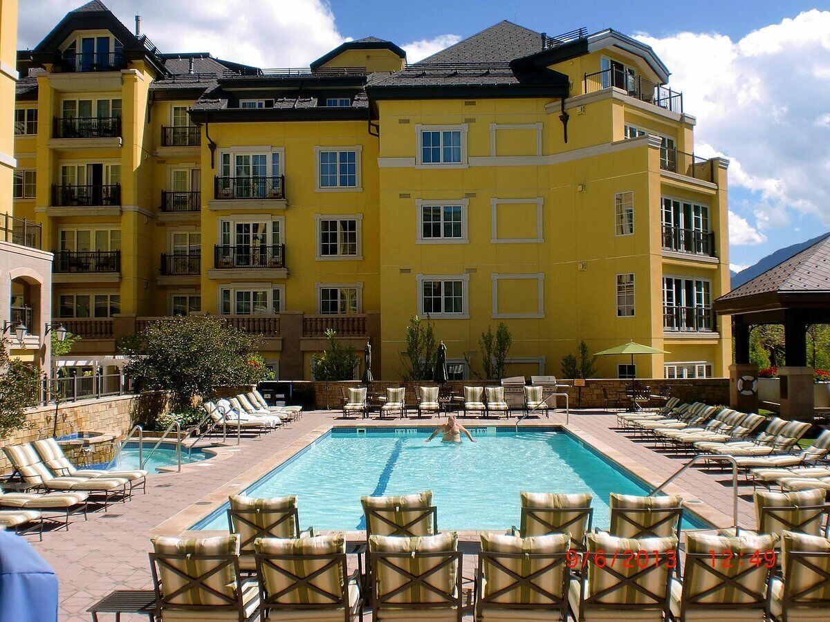 Um hotel com uma piscina grande, várias varandas e espreguiçadeiras.