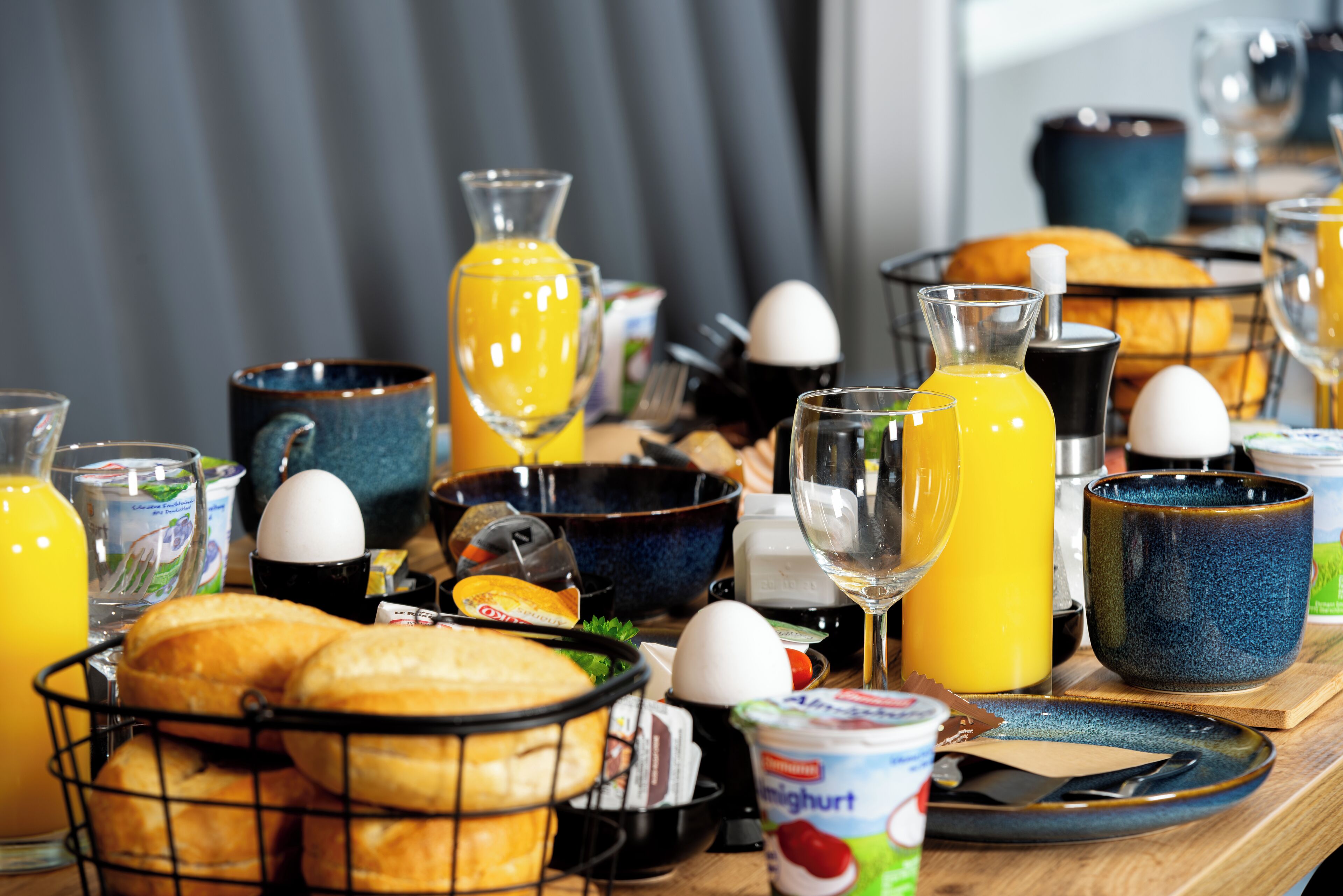 Una mesa de desayuno con diversos alimentos, bebidas y utensilios.