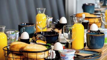 Una mesa de desayuno con diversos alimentos, bebidas y utensilios.