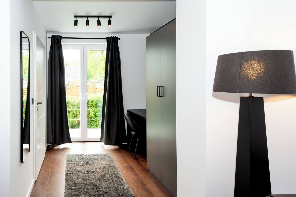 A modern hallway with a desk, a chair, and a lamp.