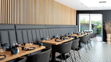 Guests can dine in comfort at this stylish dining area with tables and chairs.