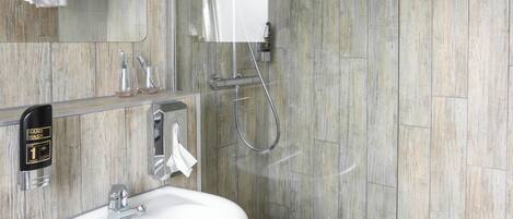 Een moderne badkamer met een douchecabine van glas, een wit wastafelmeubel en een houten wandpaneel.