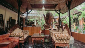 A traditional wooden interior with ornate furniture and a central decorative piece. - Rai Wood Carver and Homestay (Ubud)