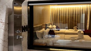 Een moderne badkamer met een douchecabine van glas, marmeren wanden en een luxe inrichting.