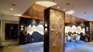 Eine moderne Lobby mit Empfangstresen, Sitzgelegenheiten und dekorativen Wandverkleidungen.