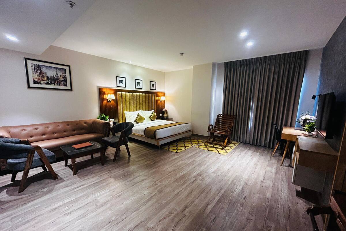 Une chambre d’hôtel moderne équipée d’un lit, d’un canapé, d’un bureau et d’une chaise.