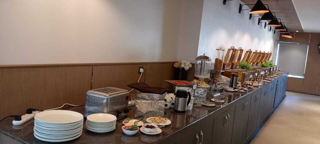 A buffet setup with plates, bowls, and various food items.