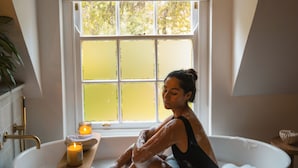A woman in a bathtub with a candle and a wooden tray. - Luxury, self-catering Manor with 6 bedrooms, views of mountains & vineyards (Klapmuts)