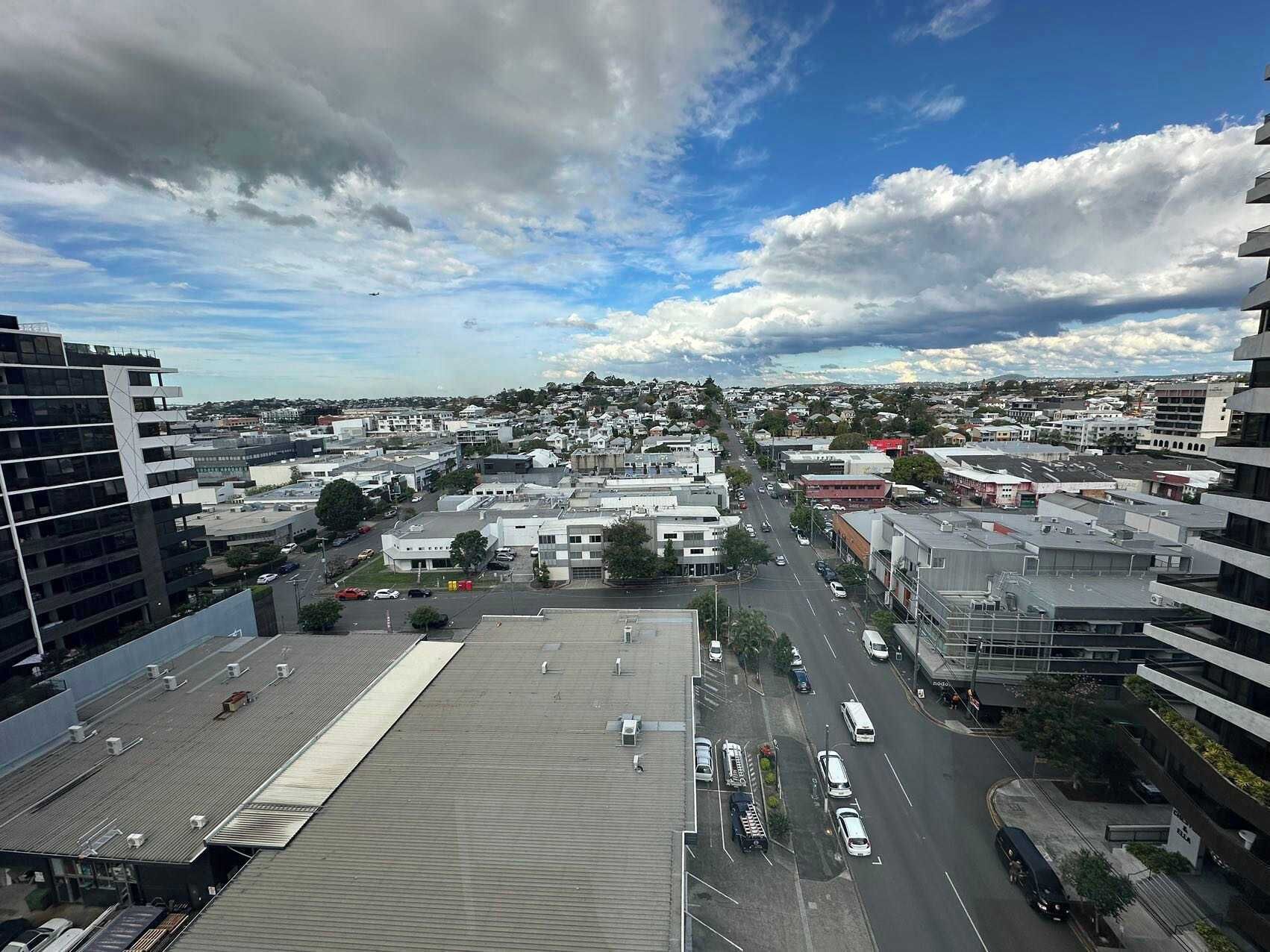 Panorama urbano con edifici moderni, un'ampia strada e cielo sereno.