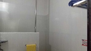 Ein Badezimmer mit Dusche, Toilette, Waschbecken und Handtuchhalter.