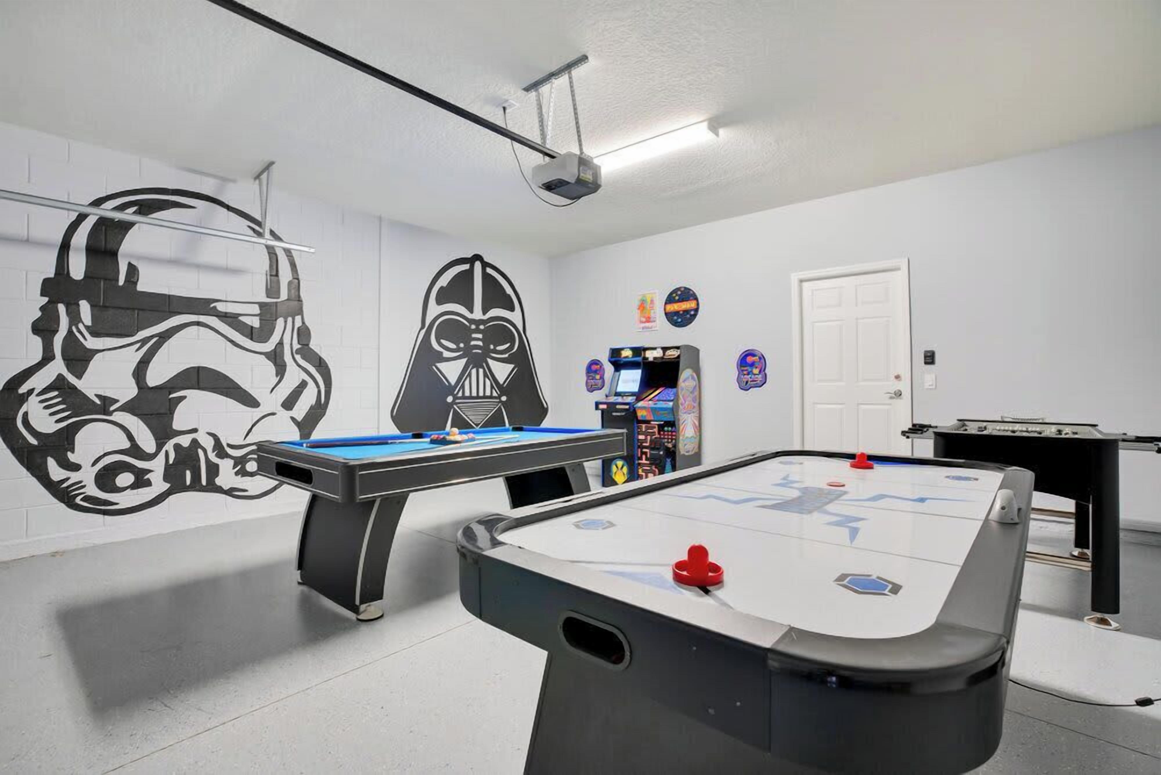 Una habitació amb taula de bitlles, taula de futbolí i decoració inspirada en Star Wars.