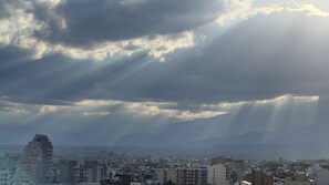 En stadsbild med utsikt över berg under en molnig himmel.