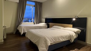 Una habitación de hotel con dos camas, vistas a la ciudad y un diseño moderno.