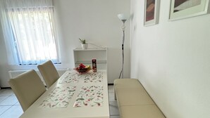 A dining area with a table set for four, a bench, a radiator, a plant, and a lamp. - H&H Home - Quite and Central Apartment near Park in Sindelfingen (Sindelfingen)