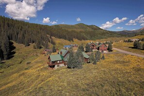 A mountainous area with multiple cabins and a road. - Creek Cove, Gorgeous home, hot tub, very private (Crested Butte)