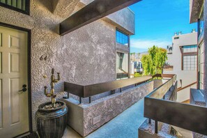 A modern building with a textured facade, a visible door, and a staircase leading to an upper level. - Palm Springs Getaway - A Ryson Property (Palm Springs)