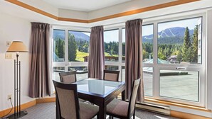 A hotel room with a large window, a table, and four chairs. - Whistler - Le Chamois - Studio #218 (Whistler)