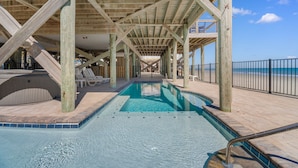 A wooden deck with a pool, lounge chairs, and a view of the beach. - 6-Bedroom Beach House w/ Private Dock & Pool in Inlet Harbour (Murrells Inlet)