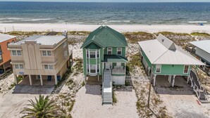 Il s'agit d'une propriété située en bord de mer, comprenant plusieurs bâtiments, notamment une maison avec une serre et un balcon, ainsi qu'une maison blanche dotée d'un porche.