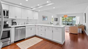 Una cocina moderna con armarios blancos, electrodomésticos de acero inoxidable y una isla grande.