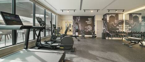 Una palestra con tapis roulant, cyclette e pesi.