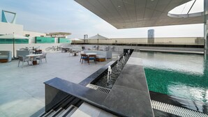 Un espace piscine aménagé sur le toit, avec des sièges et un design architectural moderne.
