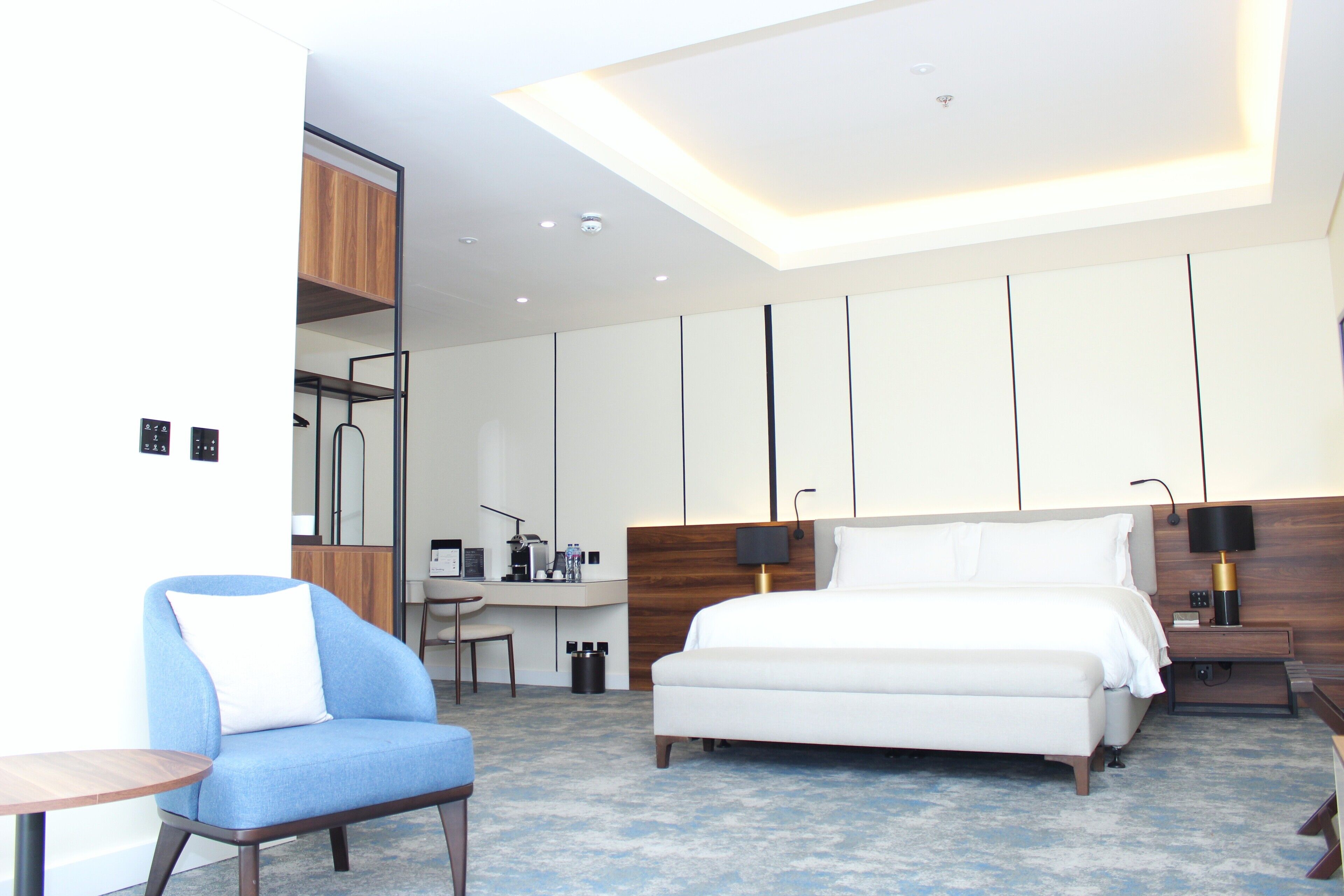 Una habitación de hotel moderna con una cama, un escritorio, una silla y una pequeña mesa.