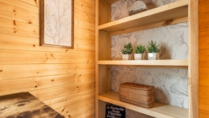 Een houten interieur met een plank waarop potplanten en een mand staan.