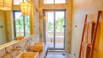 A bathroom with two sinks, a large mirror, and a glass door leading to a balcony.