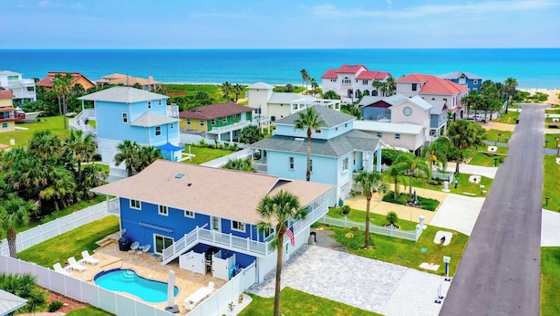 Zona residencial con casas, piscina y vista al océano.