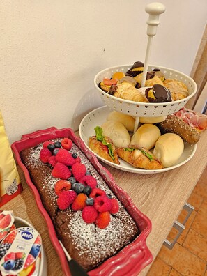 A variety of pastries and desserts on a table, including a chocolate cake with berries and a basket of assorted pastries. - Casa Giulietta B&B (Santarcangelo di Romagna)