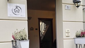 L'ingresso di un edificio con un'insegna che recita 'Casa Giulietta', una scalinata e un tappetino d'entrata con lo stesso nome.