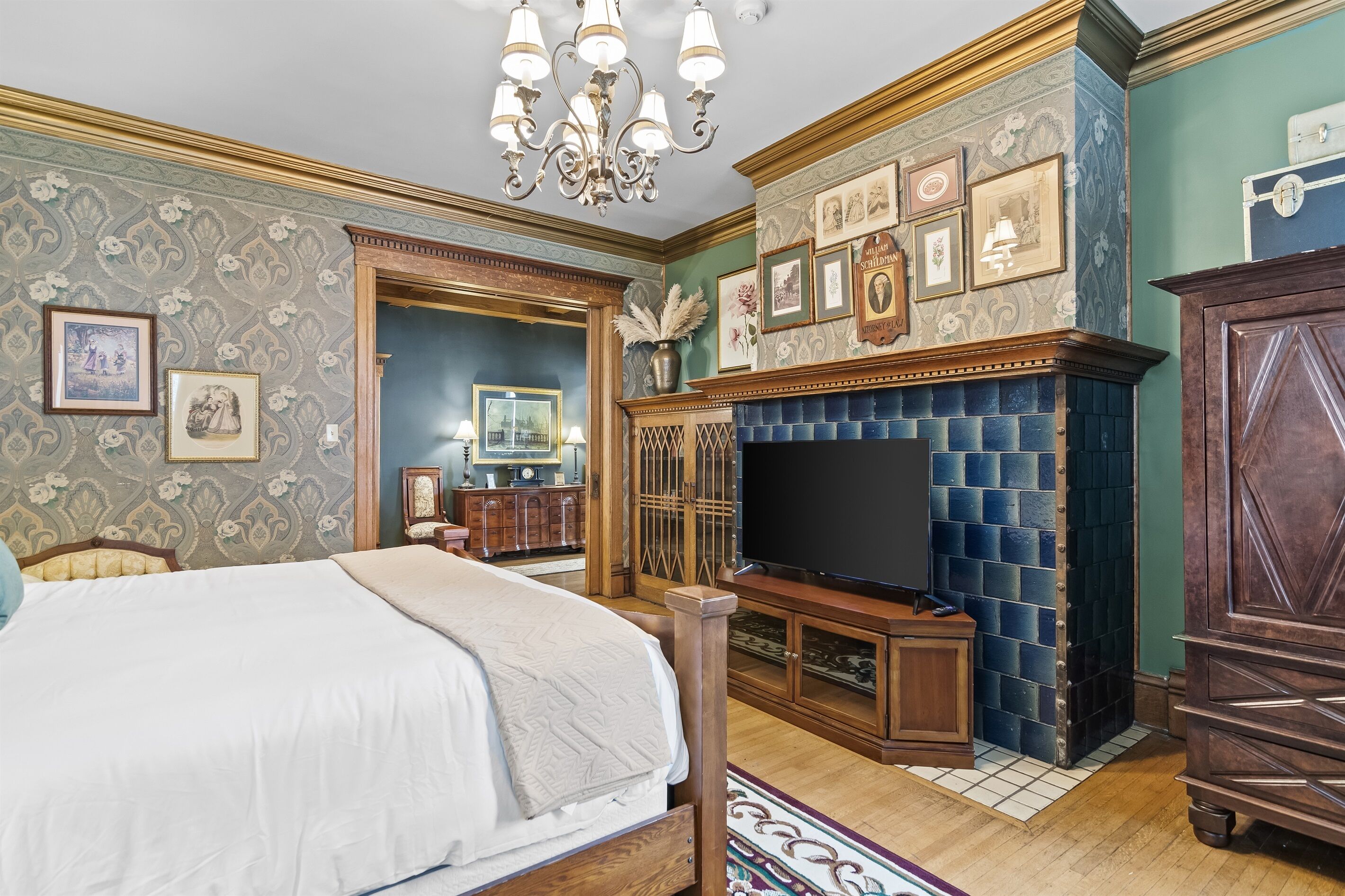 A bedroom with a large bed, a fireplace, and a television.