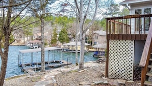 Une propriété au bord du lac, dotée d’une jetée, d’une terrasse en bois et d’un sentier en pierre.
