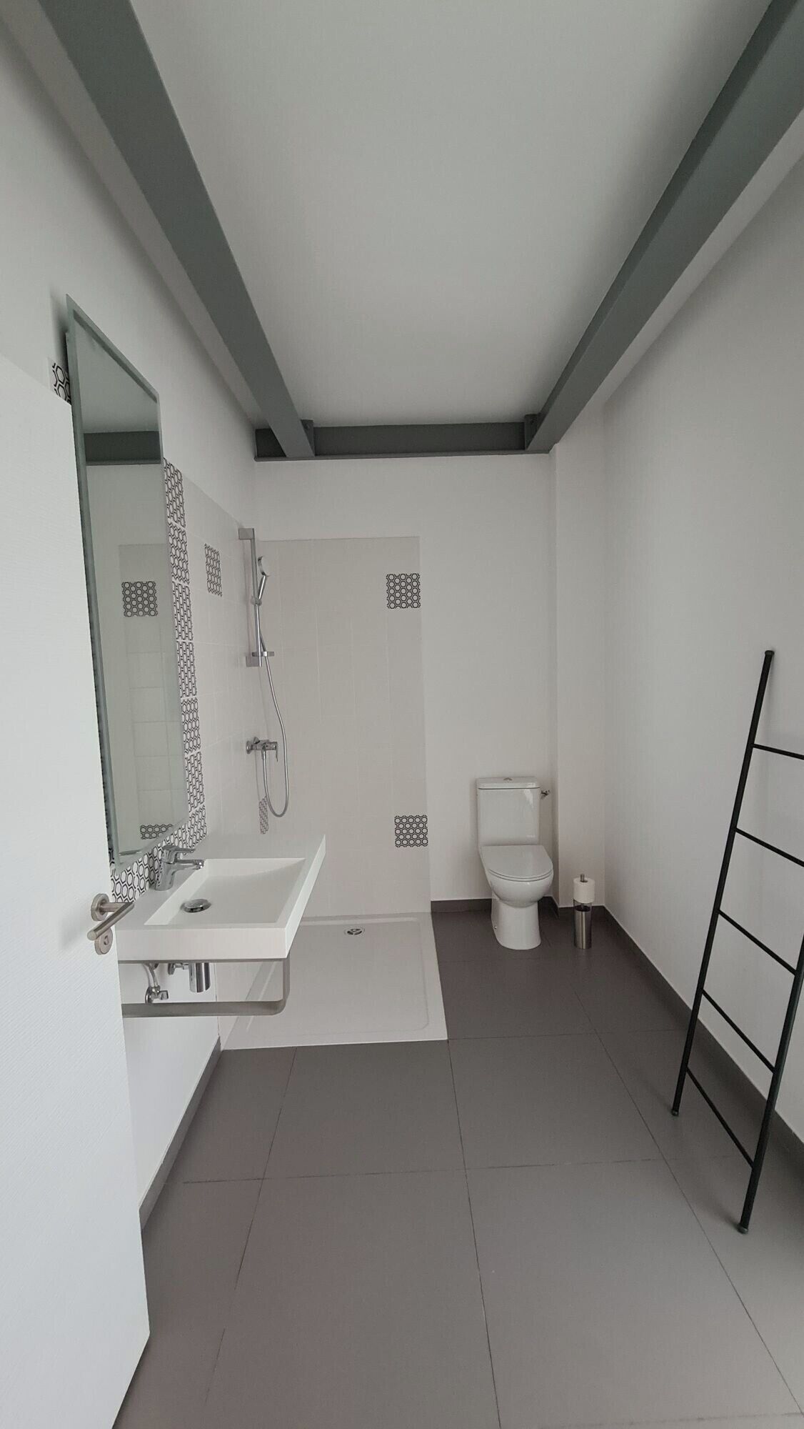 Een moderne badkamer met een wit wastafel, toilet en douchehoek.
