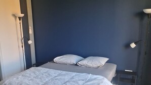 A bedroom with a bed, two bedside lamps, and a small table. - Zanzimare Casa Paolu_t2 (Eccica-Suarella)