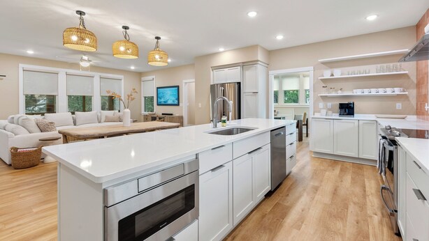 A modern kitchen with white cabinetry, stainless steel appliances, and a central island. - Creamsicle Cottage: Newly Built | Saltwater Pool (Corolla)