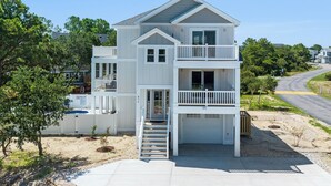 A two-story house with a front porch, a balcony on the second floor, and a garage.