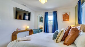 A bedroom with a bed, bedside table, lamp, mirror, and curtains. - Albuquerque Retreat w/ Hot Tub - Central Location! (Albuquerque)