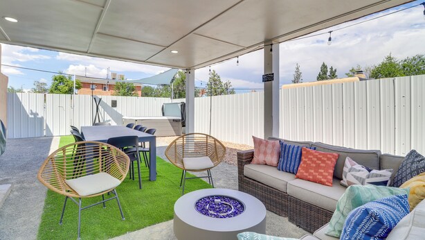An outdoor patio area with a covered seating area, a round table, and a fire pit. - Albuquerque Retreat w/ Hot Tub - Central Location! (Albuquerque)