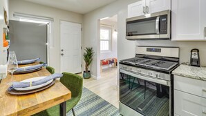 A modern kitchen with white cabinets, a stainless steel stove, and a microwave. - Albuquerque Retreat w/ Hot Tub - Central Location! (Albuquerque)